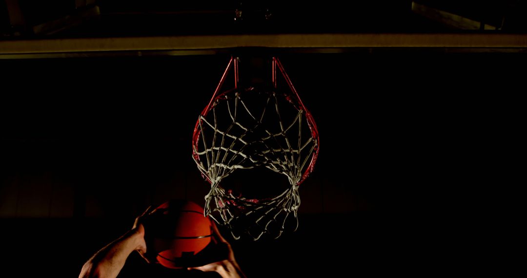 Silhouette of Basketball Player Scoring in Shadowy Gym