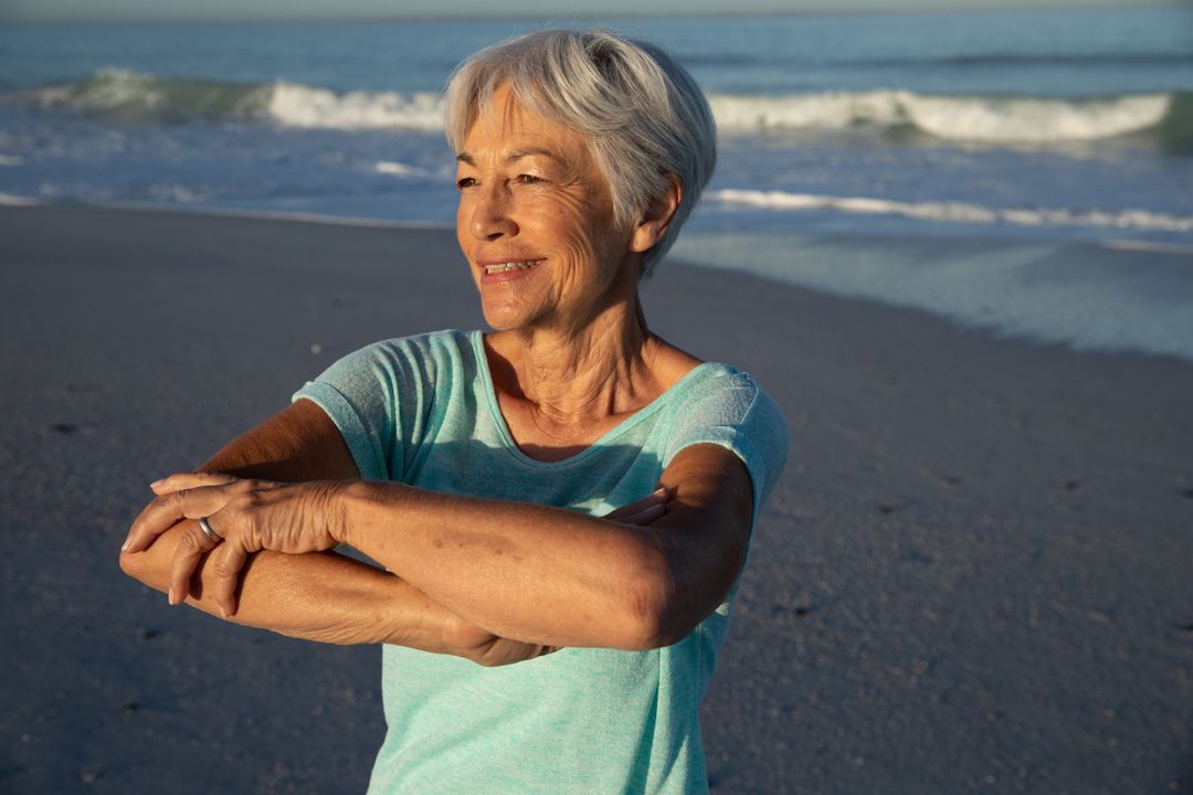 Senior Woman Stretching on Beach at Sunset - Free Images, Stock Photos and Pictures on Pikwizard.com
