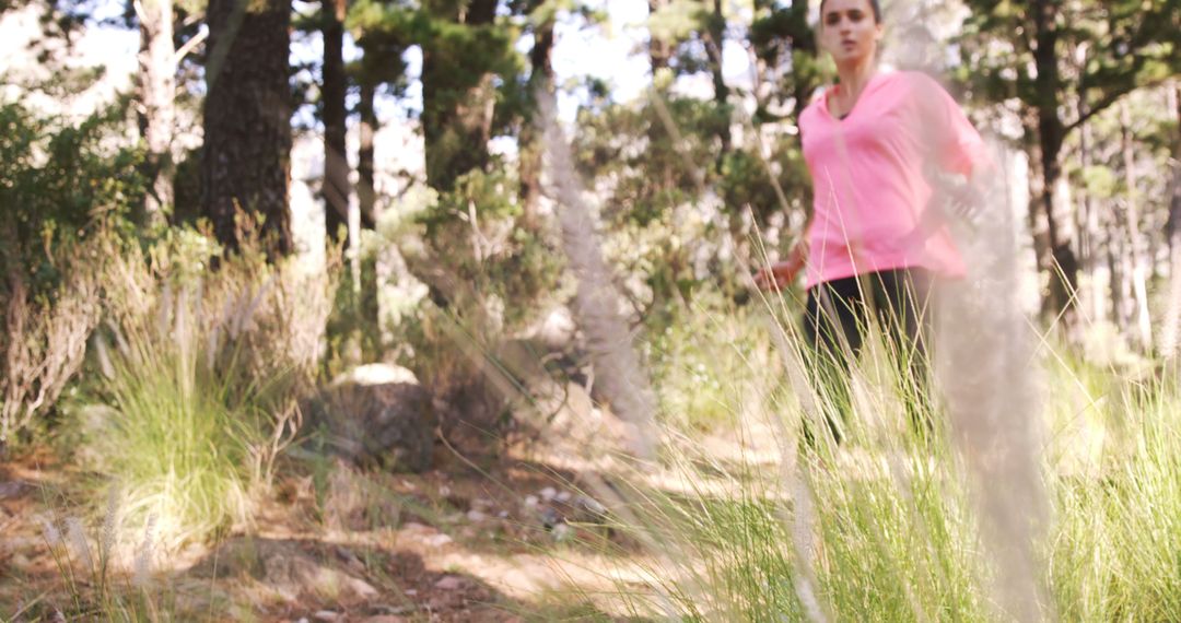 Woman jogging through forest on a sunny day - Free Images, Stock Photos and Pictures on Pikwizard.com