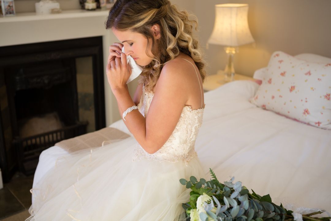 Sad bride crying while sitting on bed - Free Images, Stock Photos and Pictures on Pikwizard.com