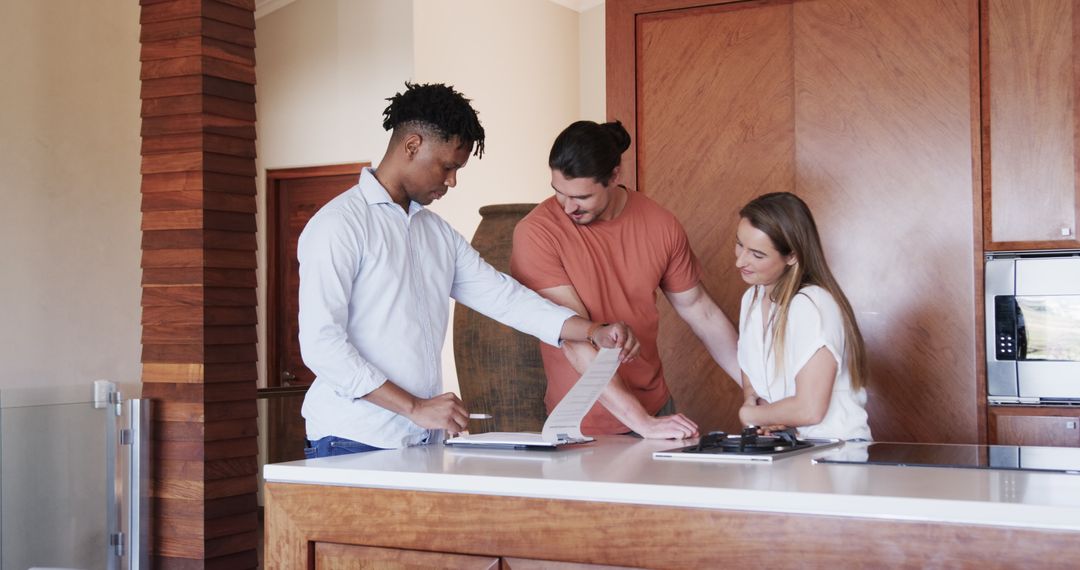 Diverse Friends Discussing Plans in Kitchen with Tablet