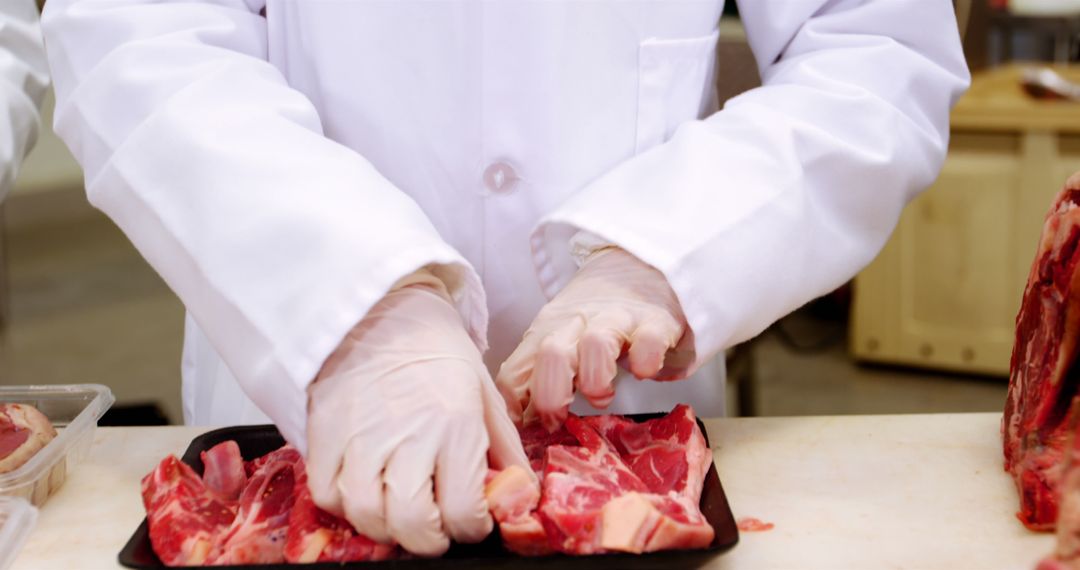 Butcher Preparing Tray of Fresh Raw Meat in Factory Setting - Free Images, Stock Photos and Pictures on Pikwizard.com