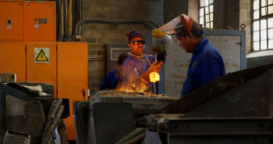 Industrial Workers Handling Molten Metal in Factory - Free Images, Stock Photos and Pictures on Pikwizard.com