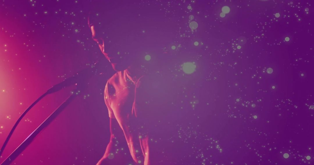 Male Performer Energizing With Microphone in Enchanting Glow