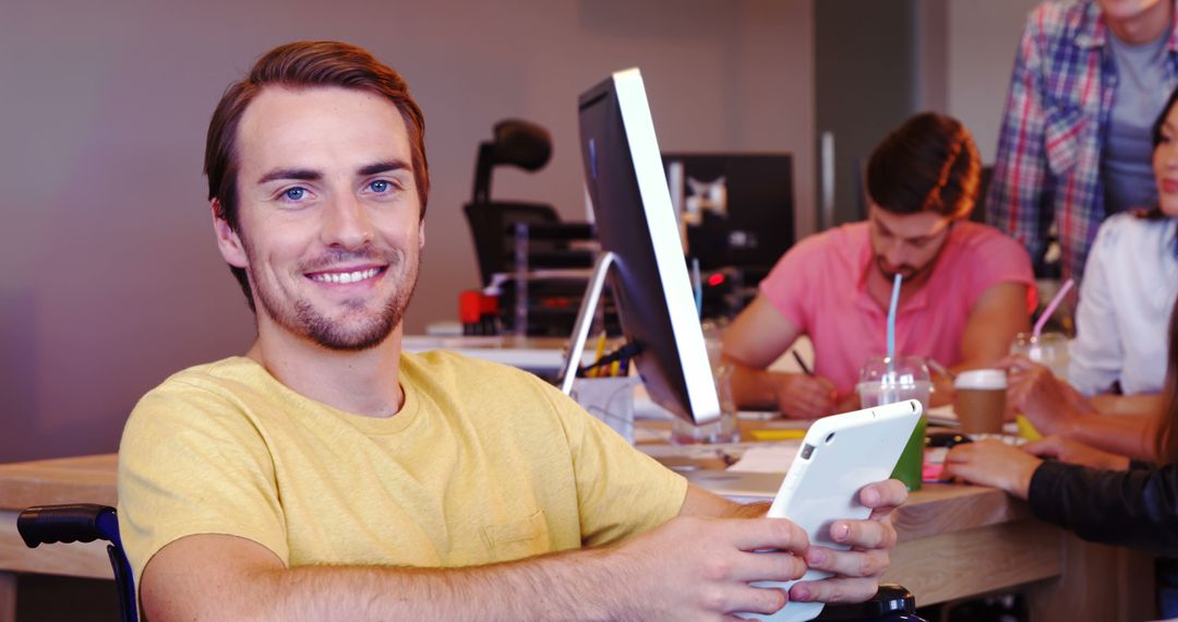 Smiling Man in Wheelchair Holding Tablet in Modern Office - Free Images, Stock Photos and Pictures on Pikwizard.com