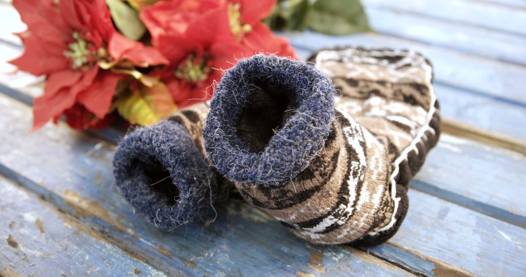 Warm Fuzzy Socks Near Festive Poinsettias on Wooden Table - Free Images, Stock Photos and Pictures on Pikwizard.com