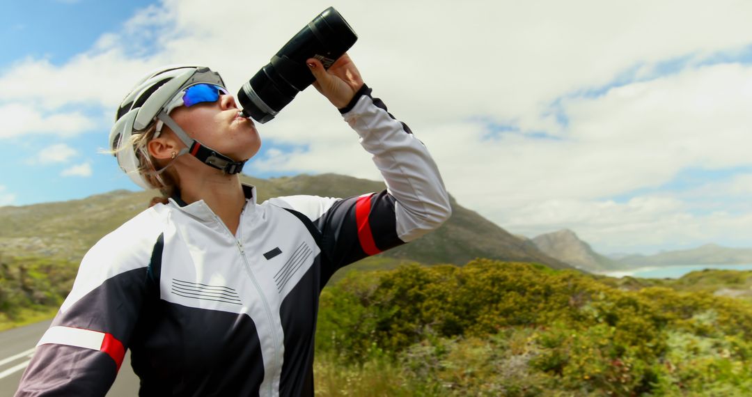 Female Cyclist Hydrating in Scenic Coastal Landscape - Free Images, Stock Photos and Pictures on Pikwizard.com