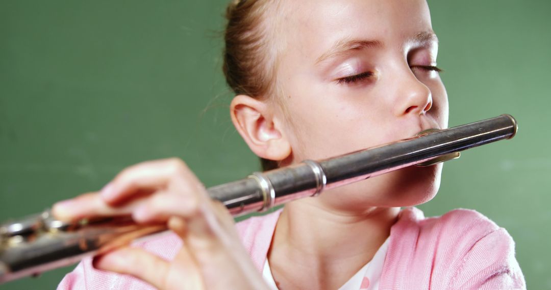 Young Girl Playing Flute with Focused Expression - Free Images, Stock Photos and Pictures on Pikwizard.com