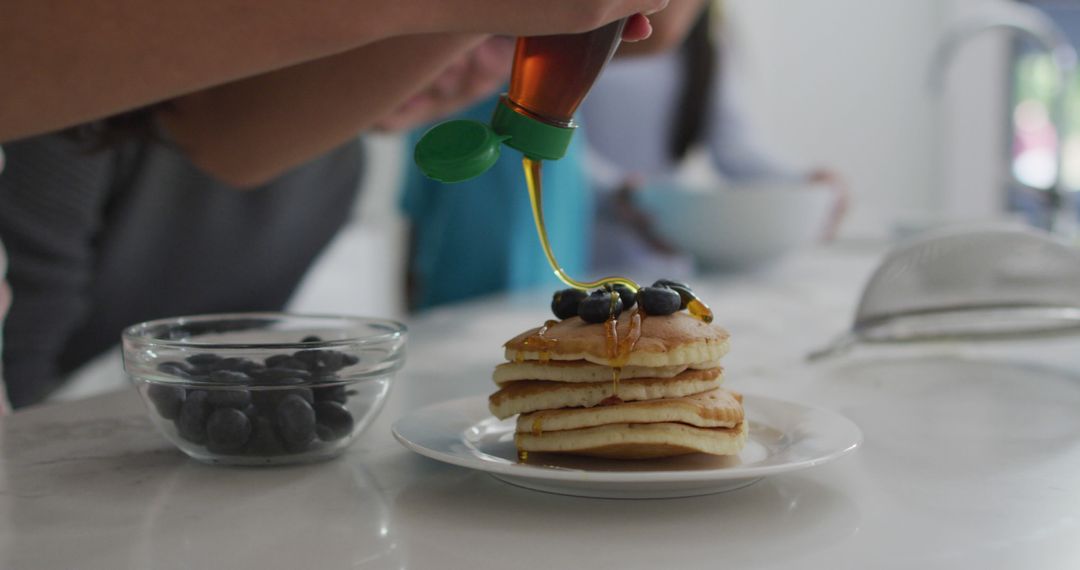 Person Pouring Syrup on Pancakes with Blueberries - Free Images, Stock Photos and Pictures on Pikwizard.com