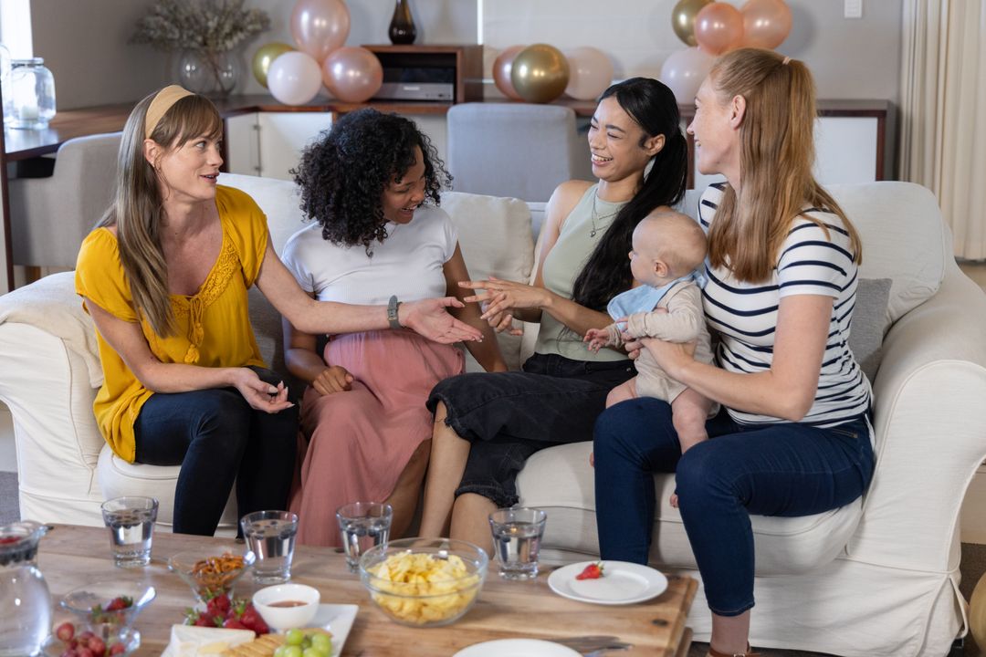 Diverse Group of Friends Relaxing with Infant in Cozy Living Room