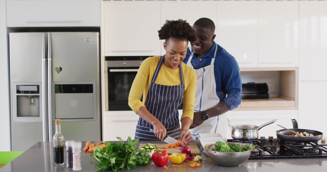 Image of happy african american couple preparing meal together in kitchen - Free Images, Stock Photos and Pictures on Pikwizard.com