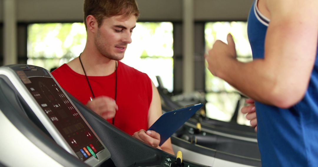 Personal Trainer Guiding Client on Treadmill in Gym - Free Images, Stock Photos and Pictures on Pikwizard.com