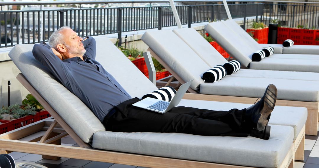 Senior Man Relaxing on Rooftop Sun Lounger with Laptop - Free Images, Stock Photos and Pictures on Pikwizard.com