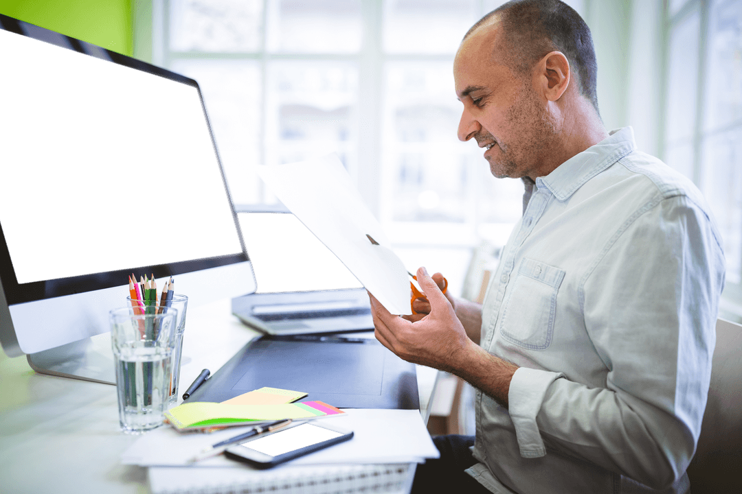 Businessman Cutting Paper at Office Desk with Transparent Screen
