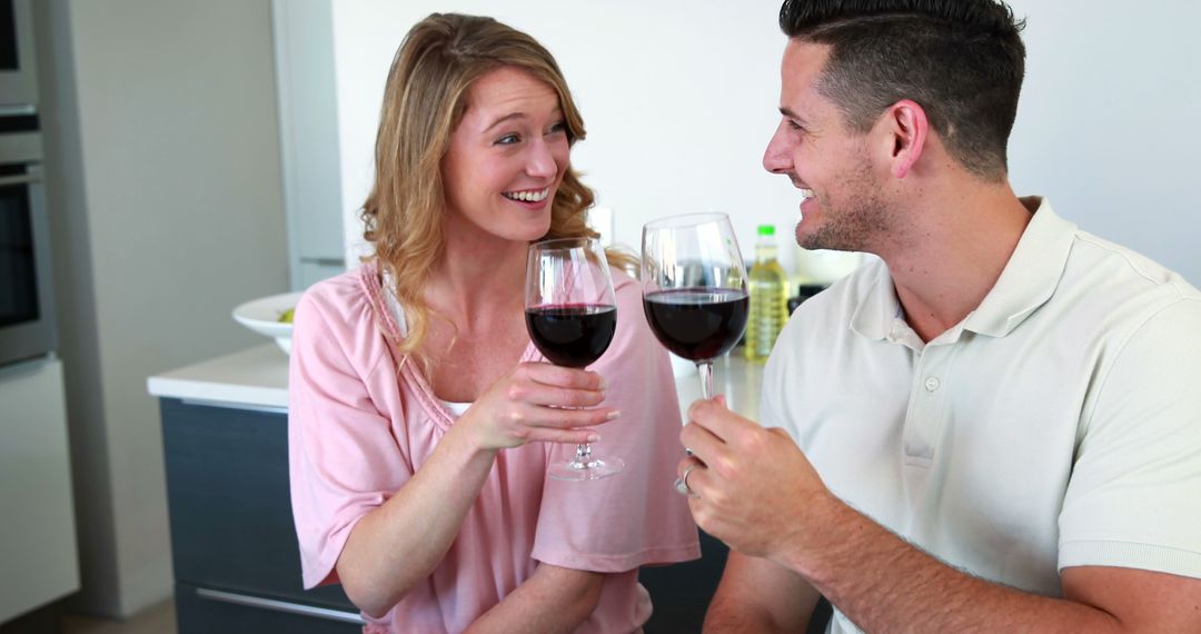 Couple Enjoying Red Wine Together in Kitchen - Free Images, Stock Photos and Pictures on Pikwizard.com