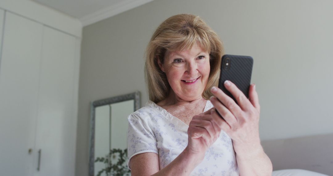 Happy senior woman texting on smartphone at home - Free Images, Stock Photos and Pictures on Pikwizard.com