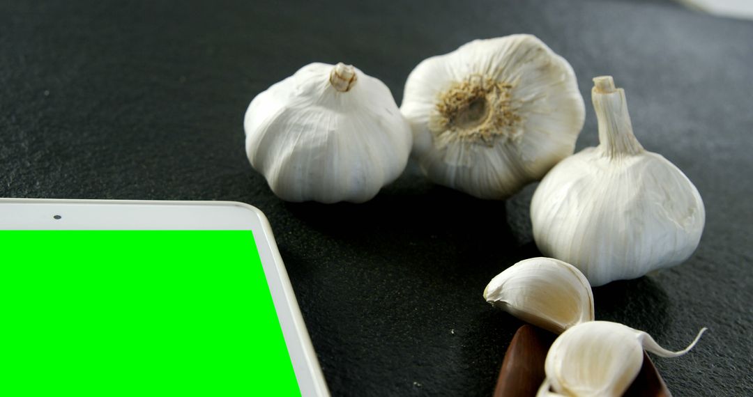 Fresh Garlic Bulbs and Cloves Next to Tablet with Green Screen - Free Images, Stock Photos and Pictures on Pikwizard.com