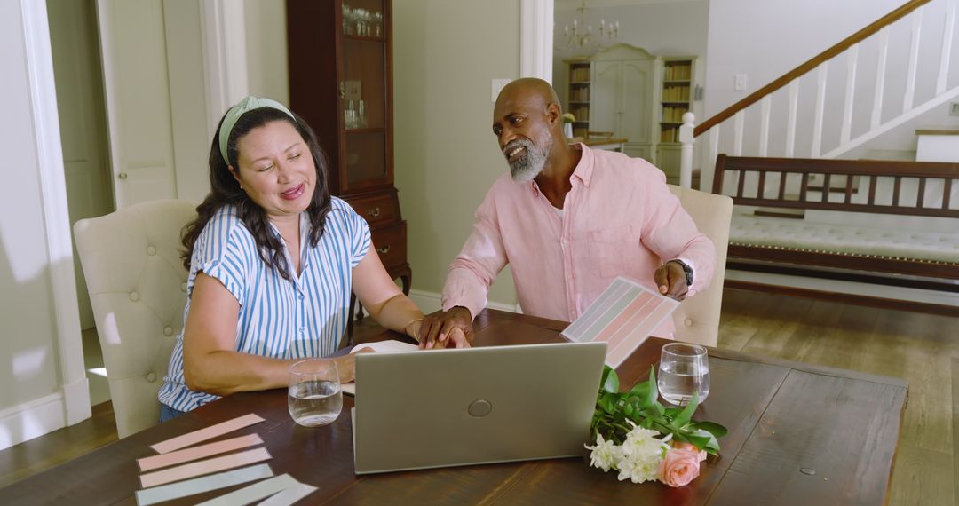 Senior Couple Planning with Laptop and Documents in Cozy Home