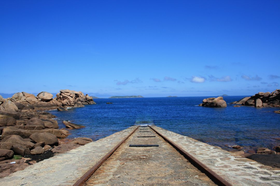 Old Railway Track Leading to Sea with Blue Sky - Free Images, Stock Photos and Pictures on Pikwizard.com