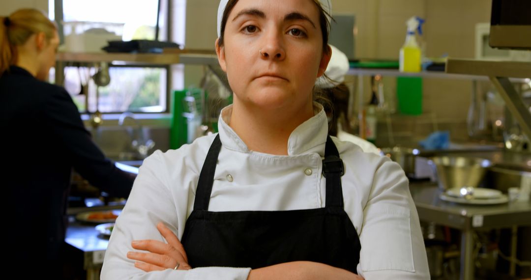 Female Chef in Kitchen With Crossed Arms Staring Seriously - Free Images, Stock Photos and Pictures on Pikwizard.com