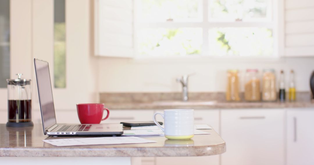 Modern Kitchen Counter with Laptop, Coffee Mugs, and French Press - Free Images, Stock Photos and Pictures on Pikwizard.com