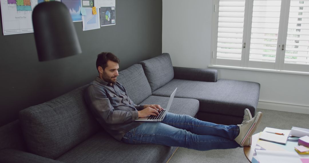 Relaxed Man Working from Home on Laptop with Innovative Ideas