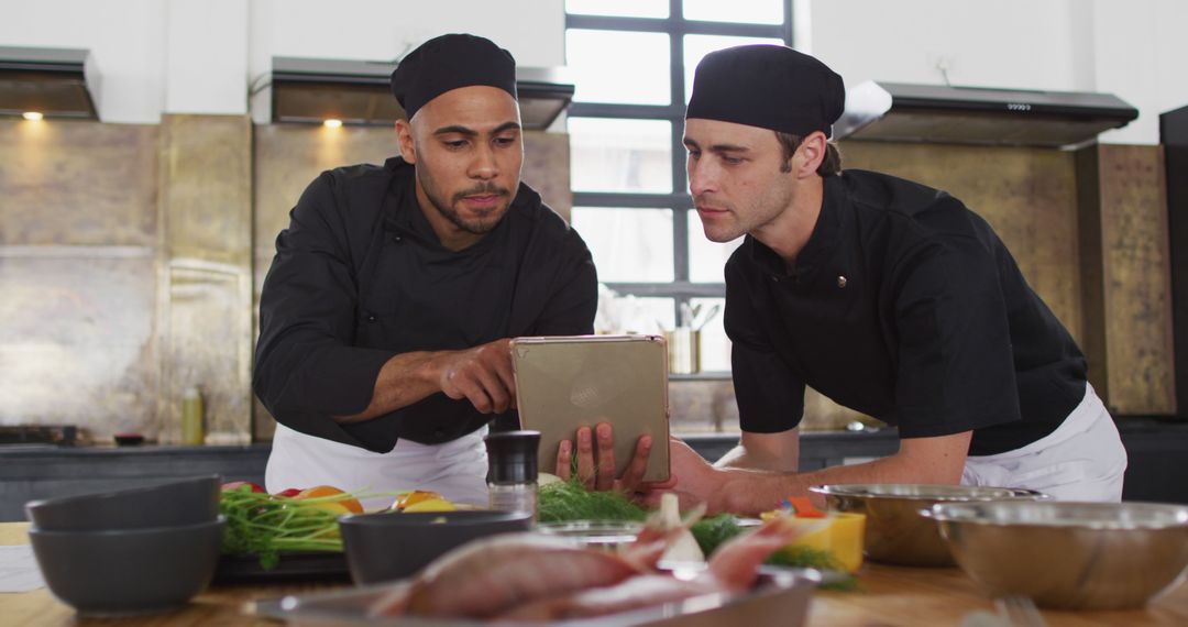 Chefs Reviewing Recipe on Tablet in Modern Kitchen - Free Images, Stock Photos and Pictures on Pikwizard.com