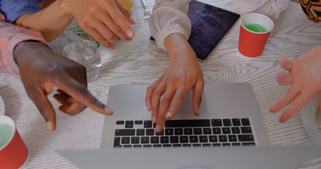 Multi-Ethnic Team Collaborating Over Laptop in Modern Office