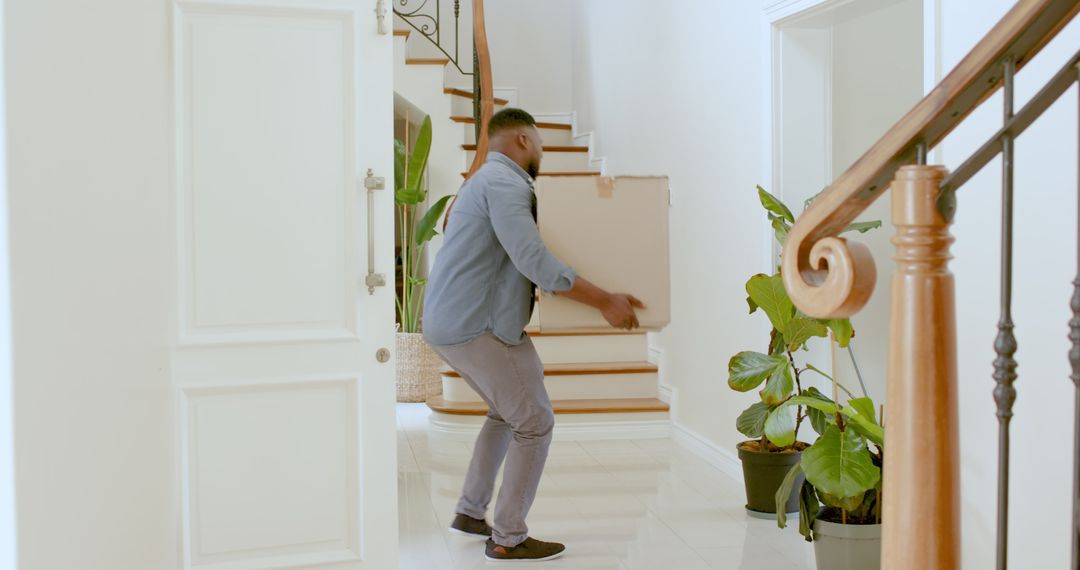 Man Unpacking Moving Boxes in Bright Modern Home Entryway