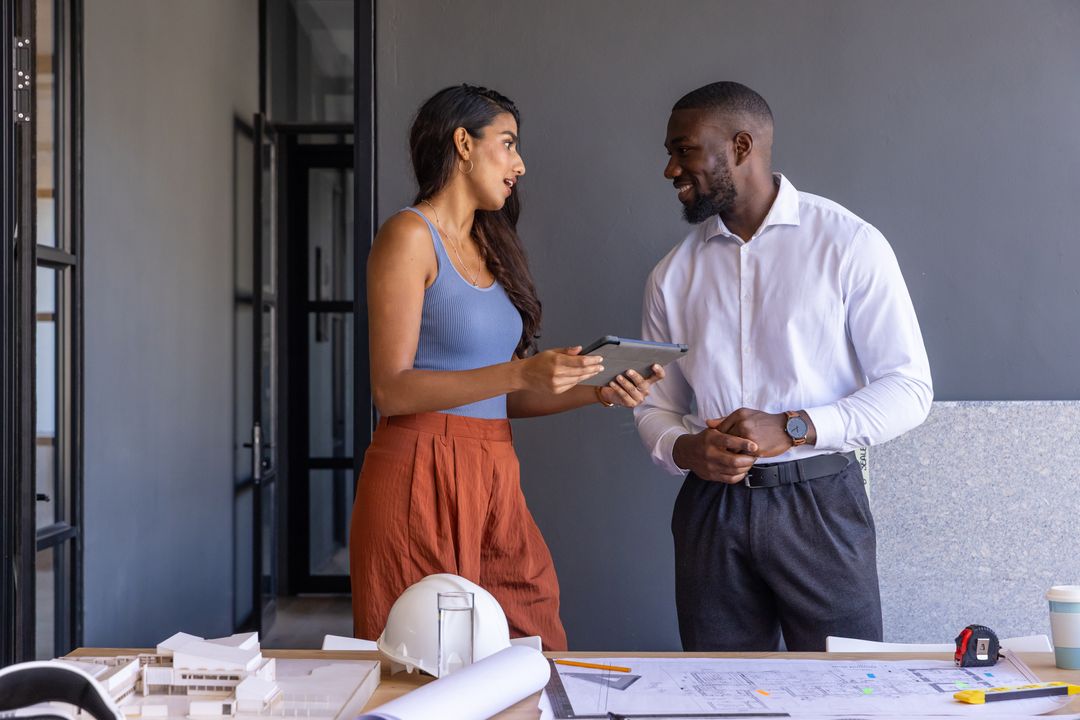 Architects Discussing Plans with Scale Model in Modern Office