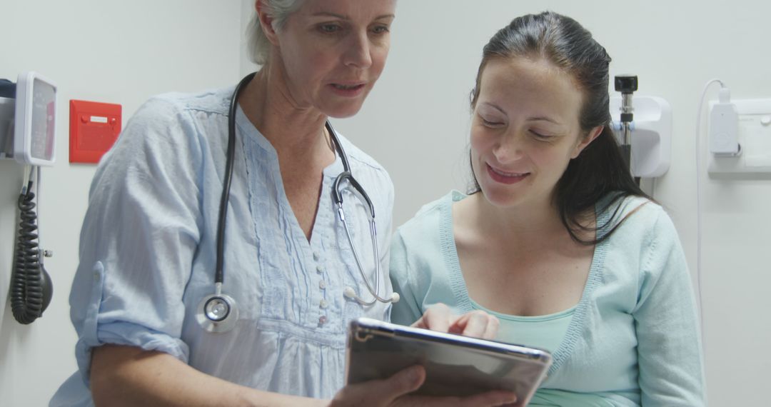 Doctor Consulting Pregnant Woman with Digital Tablet in Exam Room - Free Images, Stock Photos and Pictures on Pikwizard.com