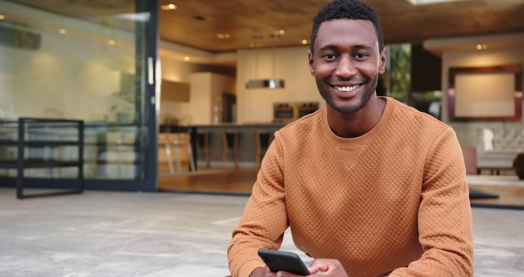Smiling Man Relaxing on Patio with Smartphone, Modern Lifestyle