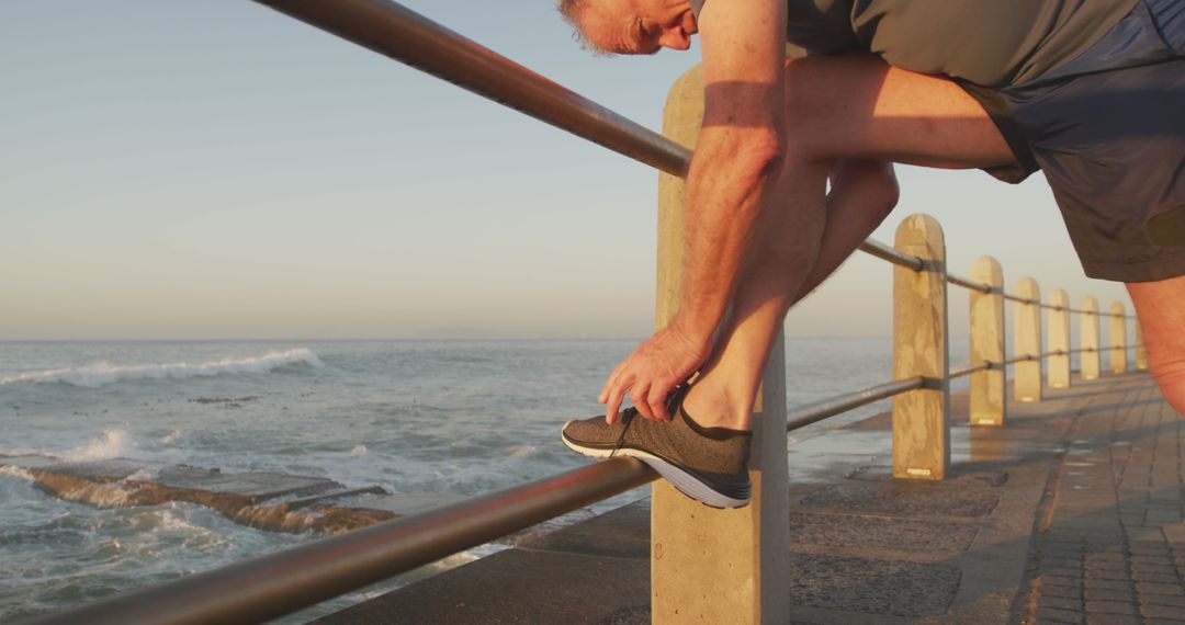 Senior Man Stretching on Seaside Promenade During Sunrise - Free Images, Stock Photos and Pictures on Pikwizard.com