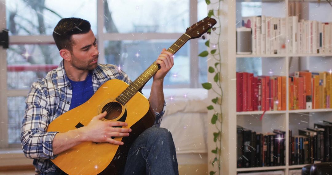 Man playing acoustic guitar in cozy home lounge with bookshelf