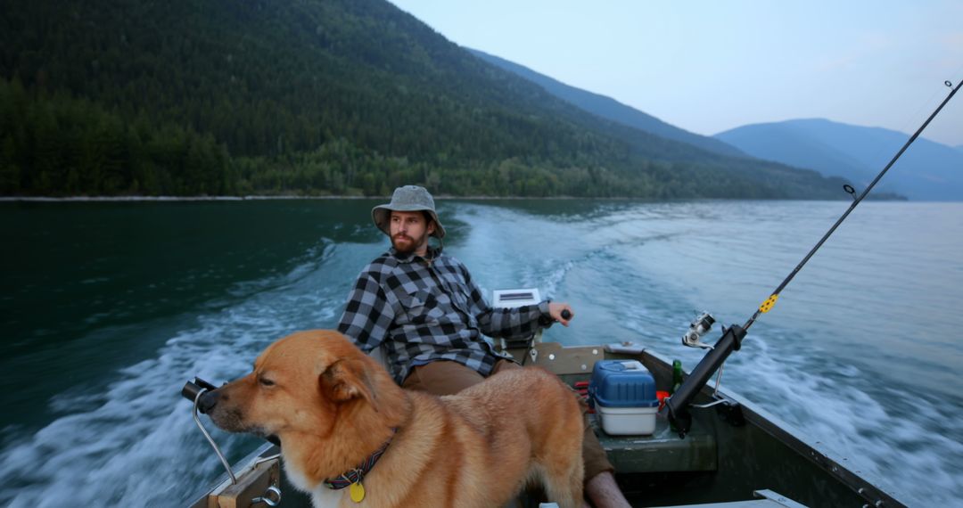 Man Fishing on Lake with Dog on Boat in Scenic Mountain Setting - Free Images, Stock Photos and Pictures on Pikwizard.com