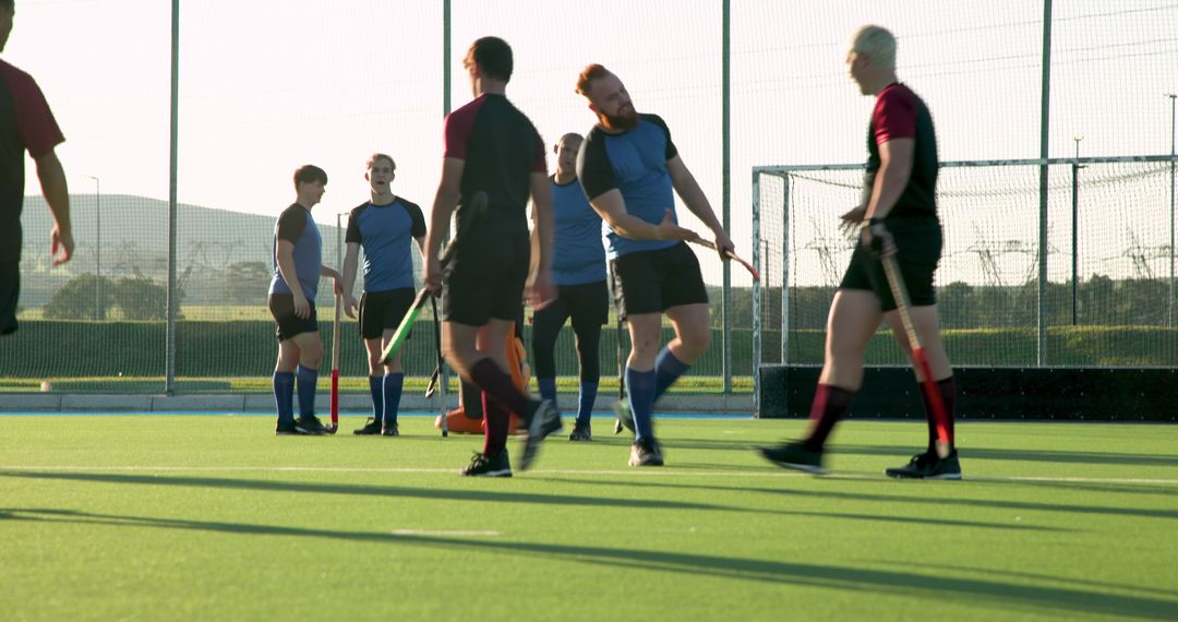 Dynamic Male Field Hockey Players Engaging in Team Exercise on Turf
