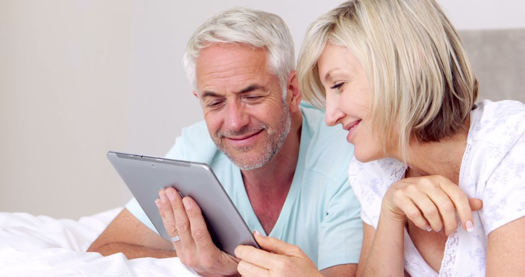 Senior Couple Relaxing Together Using Tablet in Bedroom - Free Images, Stock Photos and Pictures on Pikwizard.com