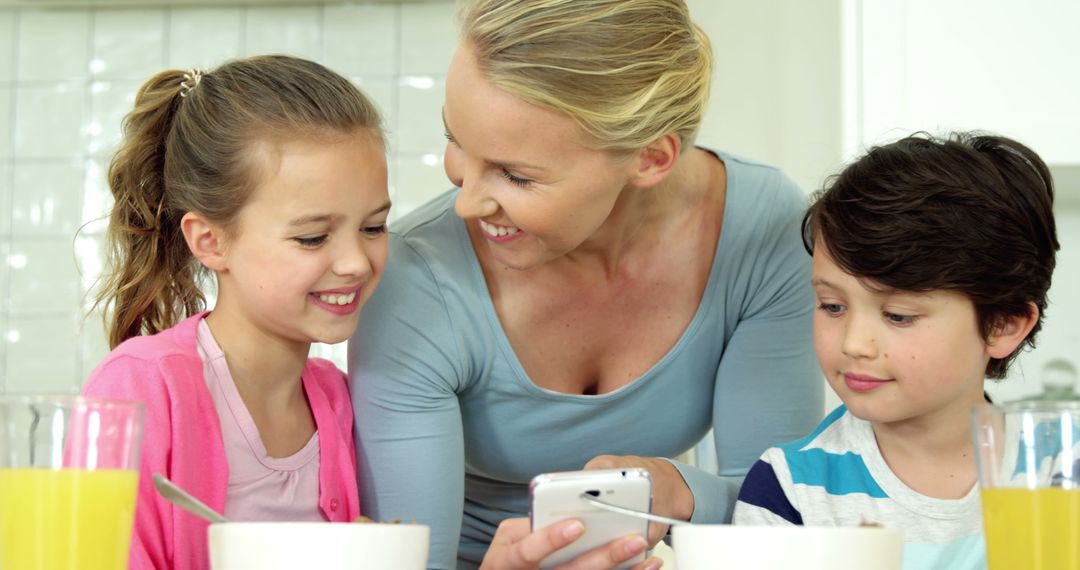 Mother with Children Smiling at Smartphone During Breakfast - Free Images, Stock Photos and Pictures on Pikwizard.com