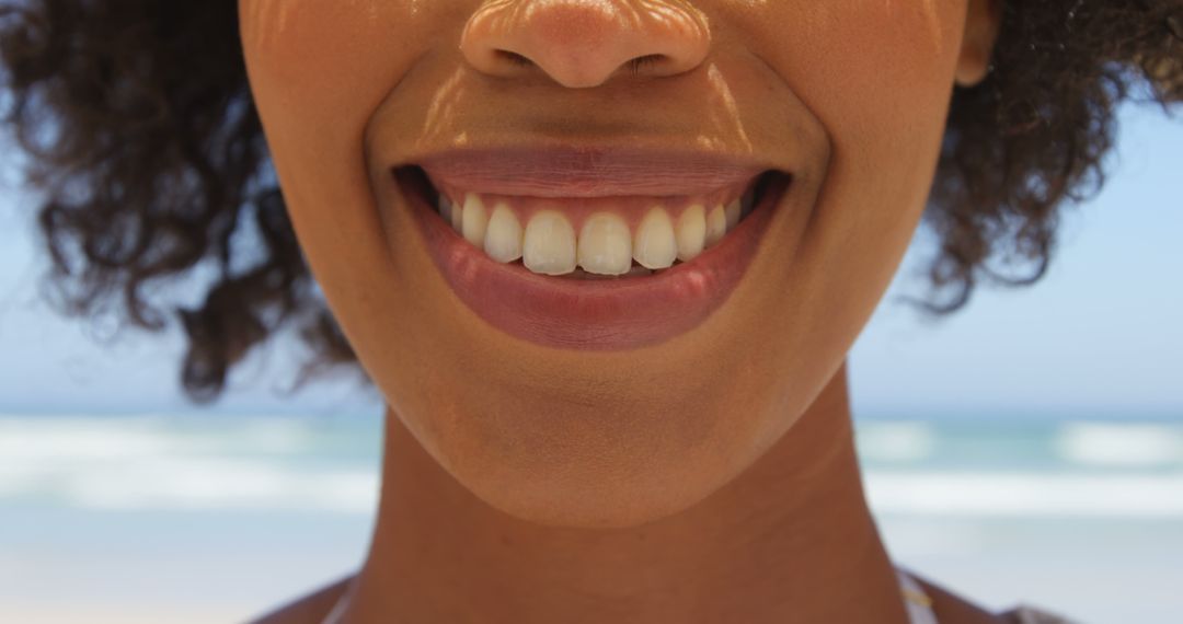 Close-up of Woman Smiling on Beach with Ocean Background - Free Images, Stock Photos and Pictures on Pikwizard.com