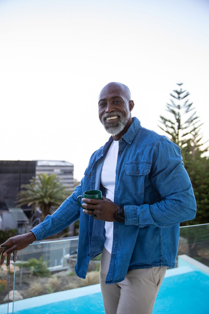 Smiling Man Enjoying Leisurely Morning by Swimming Pool