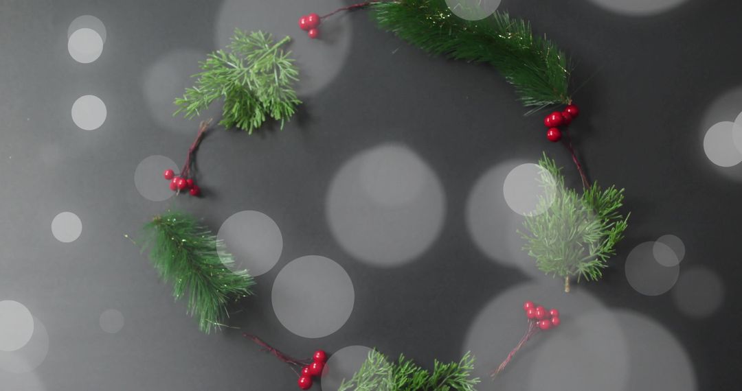 Christmas Wreath with Red Berries and Pine Branches on Dark Bokeh Background