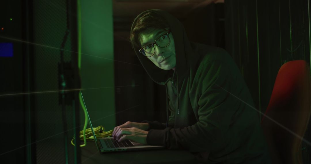 Hacker In Server Room With Laptop
