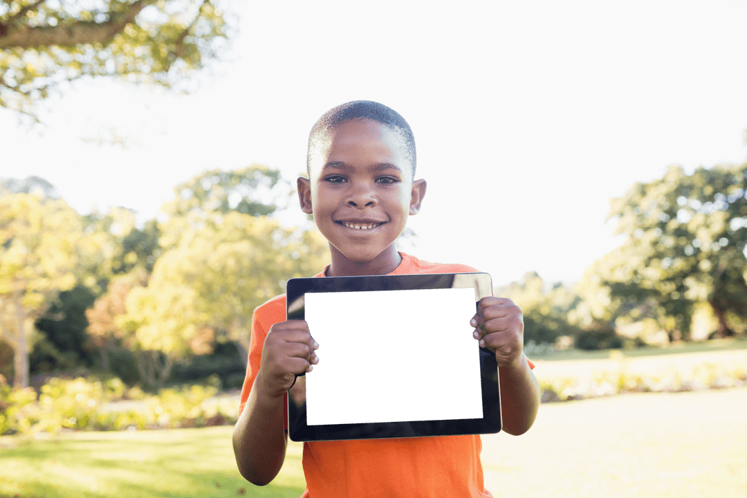 Smiling Boy Holding Transparent Tablet in Sunny Park