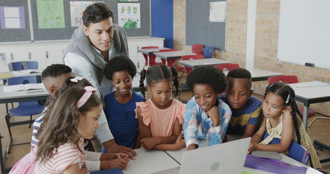 Teacher guiding diverse group of children on laptop in classroom - Free Images, Stock Photos and Pictures on Pikwizard.com