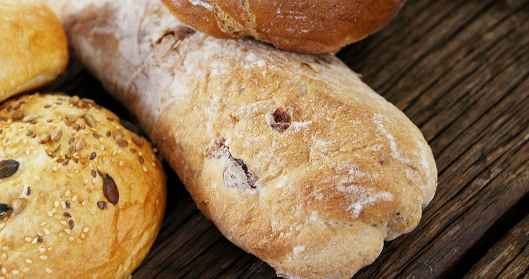 Assorted Fresh Baked Breads on Wooden Surface - Free Images, Stock Photos and Pictures on Pikwizard.com