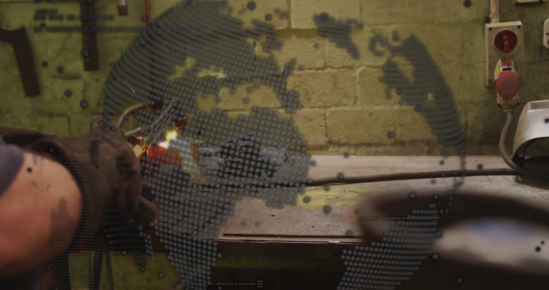 Industrial blowtorch welding on workbench with digital globe overlay and sparks