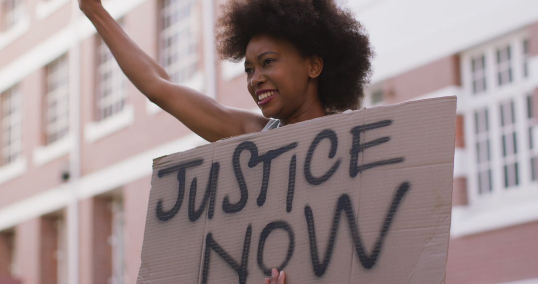 African american woman holding placard shouting raising fist during protest - Free Images, Stock Photos and Pictures on Pikwizard.com