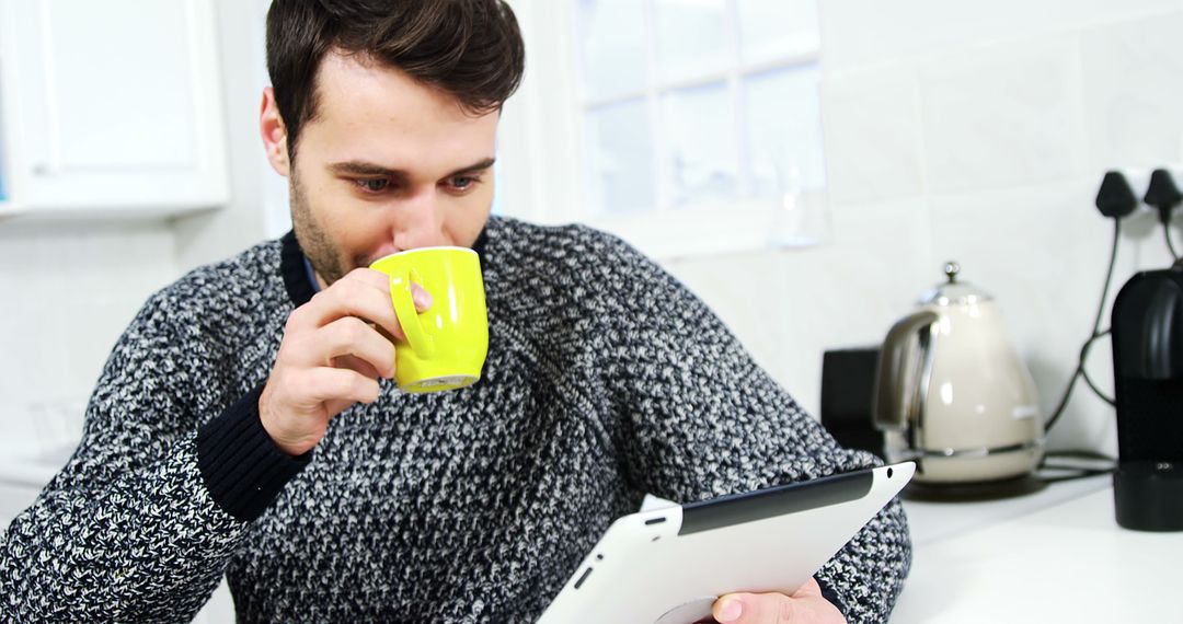 Man Enjoying Coffee and Browsing Tablet in Cozy Kitchen - Free Images, Stock Photos and Pictures on Pikwizard.com