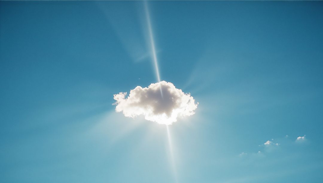 Sunbeam Backlit Cloud in Serene Blue Sky with Flare Effects