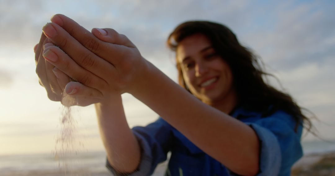 Woman Holding Sand on Beach at Sunset Smiling with Soft Focus Background - Free Images, Stock Photos and Pictures on Pikwizard.com